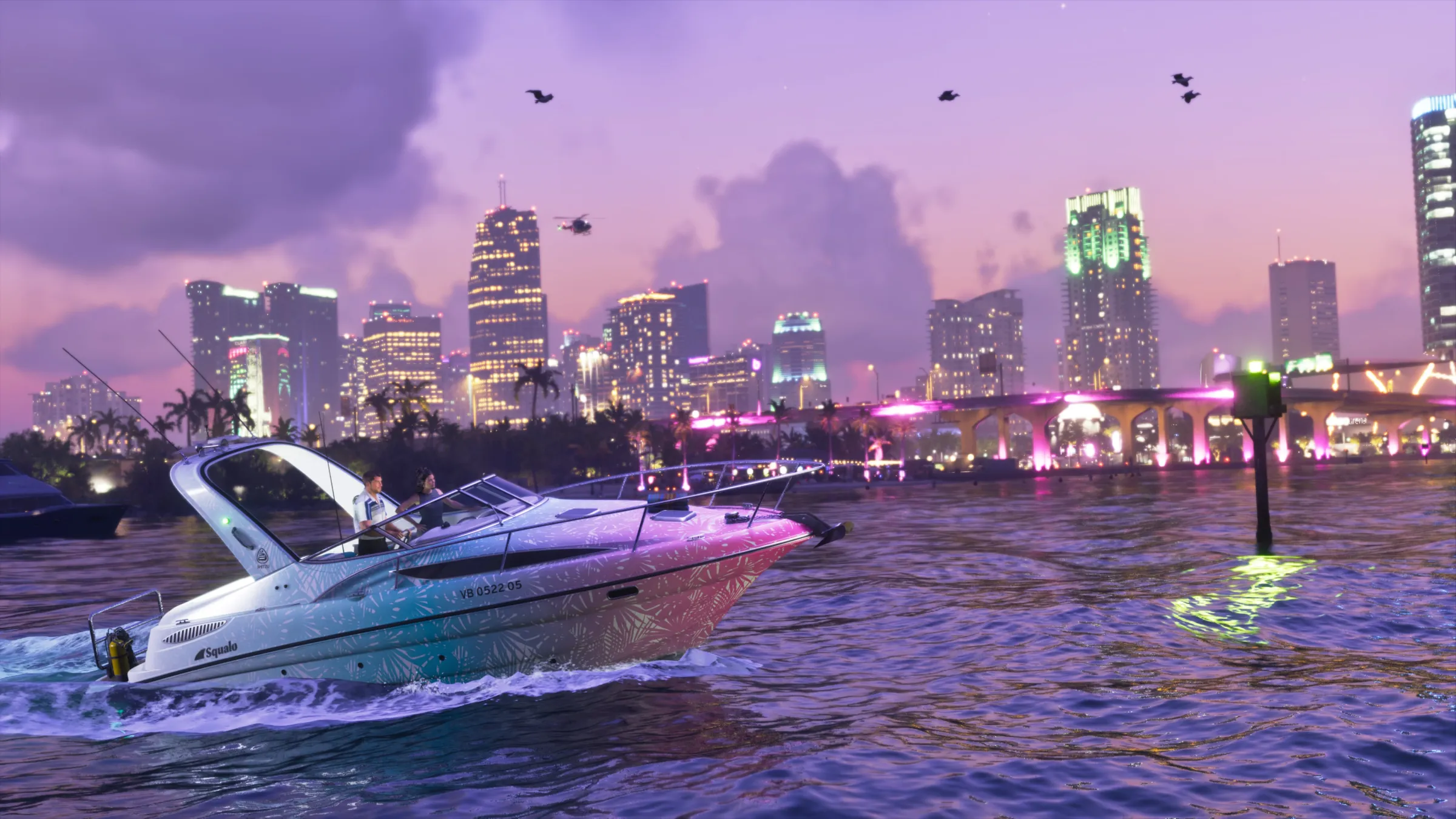 A white Squalo speedboat crosses purple water in front of an illuminated city skyline at dusk.